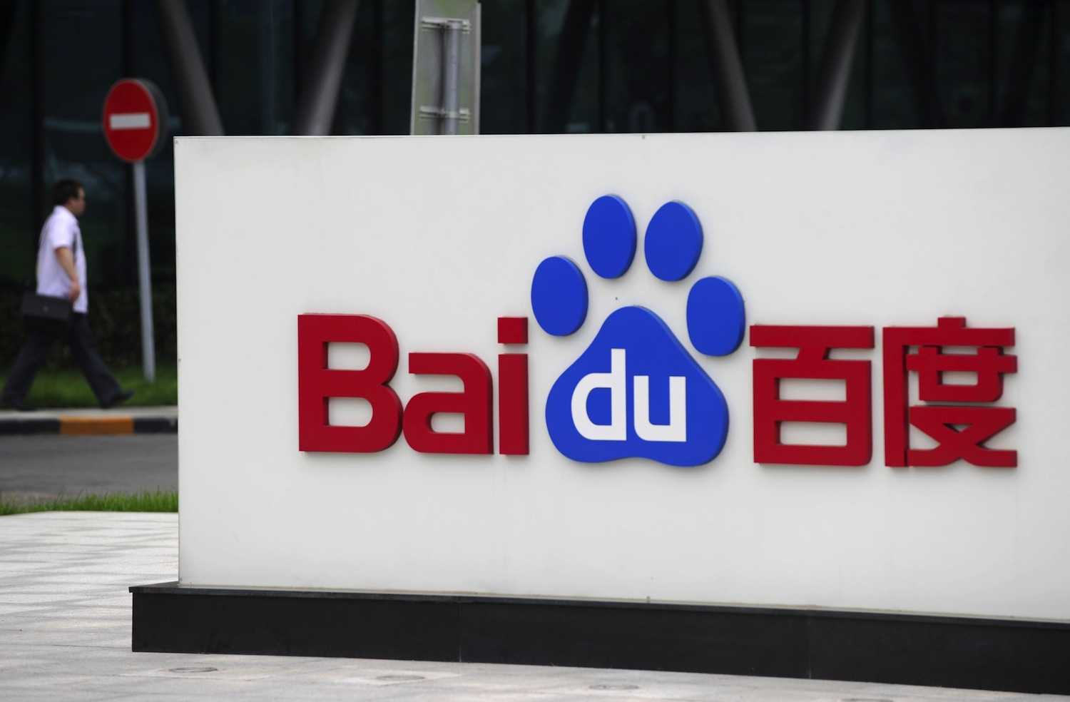 A man walks past the logo of Baidu at it